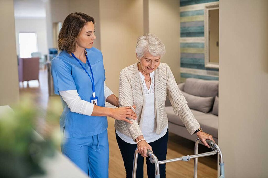 Older couple sitting together in an accessible apartment while a caregiver reviews a daily routine.